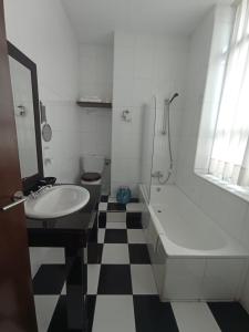 a bathroom with a black and white checkered floor at Hotel / Restaurante LA PEPA in Avilés