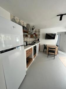 a kitchen with a white refrigerator and a table at Mel’s Garden House in the heart of the city in Bodrum City