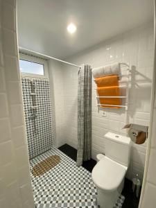 La salle de bains blanche est pourvue d'une douche et de toilettes. dans l'établissement Саквояж Вокзал, à Lviv