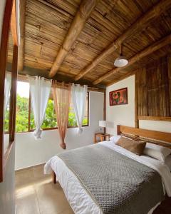 a bedroom with a bed and a large window at Cinnamon House in Mindo