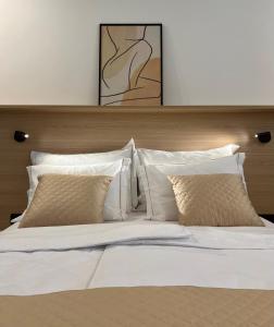 duże łóżko z białą pościelą i poduszkami w obiekcie Zaro Apartments w mieście Izola