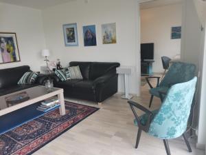 a living room with a couch and two chairs at Karlotte's apartment in Ballstad