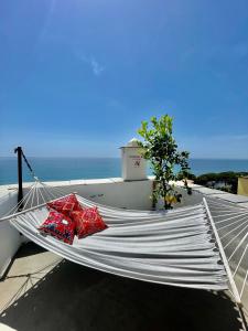 a hammock with two red pillows on top of a building at Corallini Luxury Apartments - Apartment Aka in Cervo