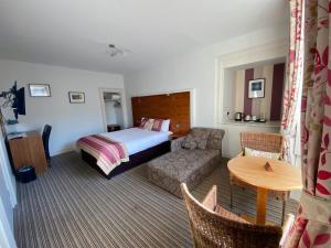 a hotel room with a bed and a couch and a table at "The County" in Selkirk