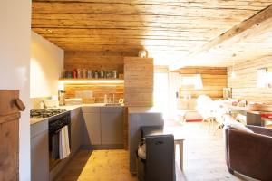eine Küche mit Holzdecken und einem Tisch im Zimmer in der Unterkunft Mountain Cabin Tschividains Lenzerheide in Obervaz