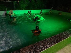 a group of people in a swimming pool at night at Creek Forest - Riverside Boutique Resort in Rishīkesh