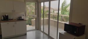a kitchen with a sliding glass door to a balcony at Desert View in Beʼer Ora