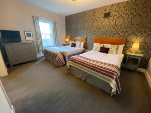 1 dormitorio con 2 camas y TV. en "The County", en Selkirk
