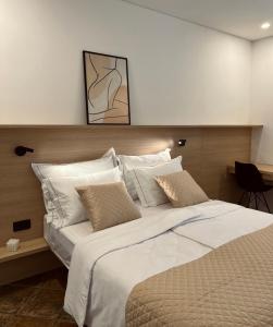 a bedroom with a large bed with white sheets and pillows at Zaro Apartments in Izola