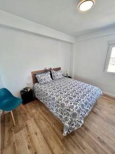 a bedroom with a bed and a blue chair at GATU El Mirador de la Viña in Cádiz