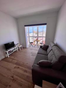 a living room with a couch and a flat screen tv at GATU El Mirador de la Viña in Cádiz