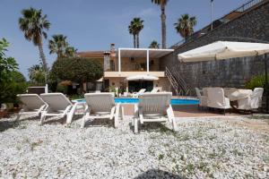 een groep witte stoelen en een zwembad bij B&B Villa Meridiana in Diamante