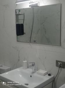 ein weißes Badezimmer mit Waschbecken und Spiegel in der Unterkunft Studiou Andu Nord 10 by Alezzi in Năvodari + 13 Fotos