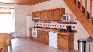 a kitchen with wooden cabinets and white appliances at Gites Le Clos de Lamie avec 2 piscines privées in Fossemagne