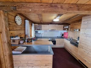 a kitchen with wooden walls and a clock on the wall at Almhütte Chrisanten Thaya Sölden in Sölden