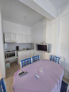 アギア・パラスカヴィにあるMare - Roomsのキッチン(テーブル、椅子、紫色のテーブルクロス付)