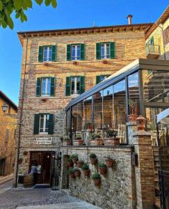 a brick building with potted plants in front of it at RESIDENCE IL GROTTINO in Gualdo Cattaneo