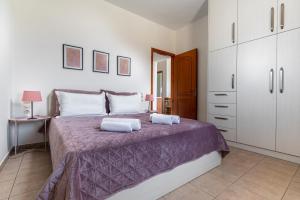a bedroom with a large bed with a purple blanket at Sea view Pine house in Makry Gialos +29 photos