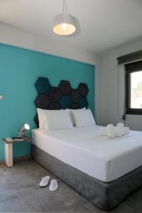 een slaapkamer met een groot wit bed en een blauwe muur bij STREET 90 Luxury Apartment in Keramotí