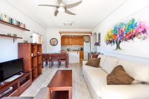 a living room with a white couch and a ceiling fan at Espanhouse Rio Mar in Pilar de la Horadada