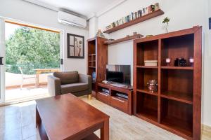 a living room with a wooden entertainment center and a table at Espanhouse Rio Mar in Pilar de la Horadada