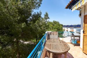 a balcony with a wooden chair on a blue railing at Espanhouse Rio Mar in Pilar de la Horadada