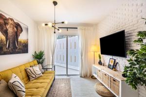 uma sala de estar com um sofá amarelo e uma televisão de ecrã plano em Refugio Vacacional em Granadilla de Abona