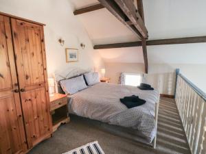 Un dormitorio con una cama y un armario de madera. en Farndale, en Whitby