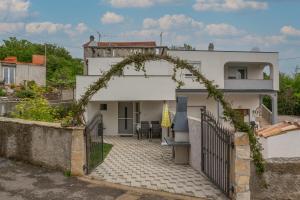 vistas a una casa con un arco sobre un patio en Apartman Marija 218, en Risika