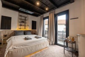 a bedroom with a large bed and a balcony at Bashtin Dom - Skabrin House in Bansko