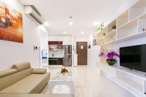 ein Wohnzimmer mit einem Sofa und einem TV in der Unterkunft 3BR-ICON56-City View-Hanas Apart in Ho-Chi-Minh-Stadt