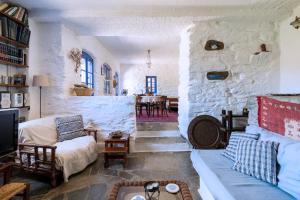 a large living room with a stone wall at Traditional Village House On Kea in Milopótamos