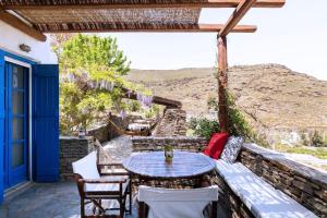 a table and chairs on a patio with a view at Traditional Village House On Kea in Milopótamos