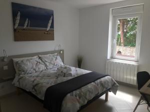 a bed in a bedroom with a window and a bedspread at BlackBerry Cottage - Maison de vacances - with WIFI in Lessay