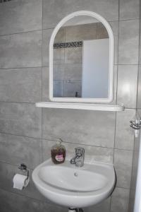 a bathroom with a white sink and a mirror at Giorgos-Fenia Apartments in Paralia Katerinis