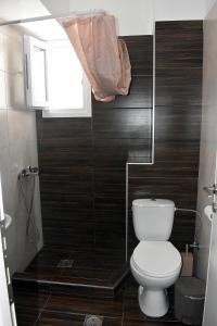 a bathroom with a toilet and a window at Giorgos-Fenia Apartments in Paralia Katerinis
