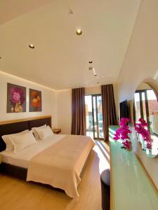 1 dormitorio con 1 cama grande y mesa de cristal en Hotel Nertili, en Sarandë