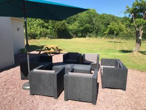 un grupo de sillas y una mesa de picnic con sombrilla en BlackBerry Cottage, en Lessay
