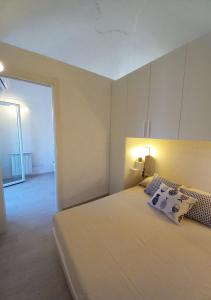 1 dormitorio con 1 cama blanca grande en una habitación en Da Patrizia, en Porto Santo Stefano