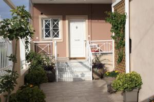 a hallway with potted plants and a white door at Asteri Apartments Mytikas 2-Bedroom Seaview Courtyard in Mitika