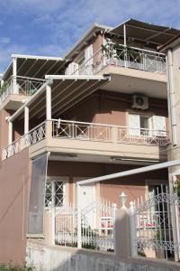 a pink apartment building with balconies on the side of it at Asteri Apartments Mytikas 2-Bedroom Seaview Courtyard in Mitika