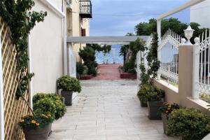 a walkway with potted plants and a white fence at Asteri Apartments Mytikas 2-Bedroom Seaview Courtyard in Mitika