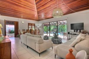 a living room with couches and a flat screen tv at Villa La Luz in Sainte-Anne