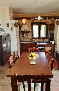 Casa Trachini في بالمي: مطبخ مع طاولة وكراسي خشبية في الغرفة