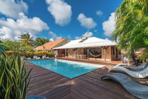 a villa with a swimming pool and a house at Villa La Luz in Sainte-Anne