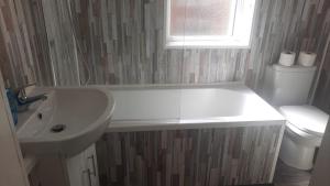 uma casa de banho com um lavatório branco e um WC. em Alexander Apartments City North em Newcastle upon Tyne
