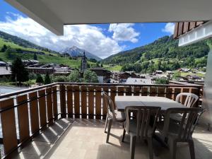 Un balcón con mesa y sillas y una vista en Crystal 14 - Appartement centre village, en La Clusaz