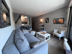 ein Wohnzimmer mit einem blauen Sofa und einem Tisch in der Unterkunft Crystal 15 - 2 pieces centre in La Clusaz