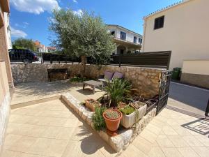einen Garten mit einer Bank und Pflanzen im Hof in der Unterkunft Borik Hills in Zadar