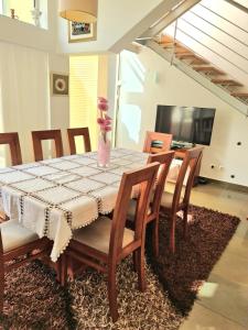 een eettafel met een vaas met bloemen erop bij Varandas do Carvoeiro in Carvoeiro